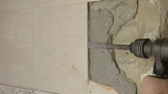 Demolition Hammer Breaking the Tiled Wall