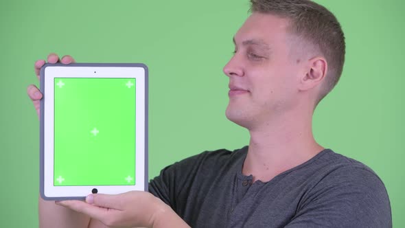 Face of Happy Young Man Showing Digital Tablet