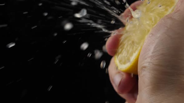 Slow Motion squeeze juice from lemon close up