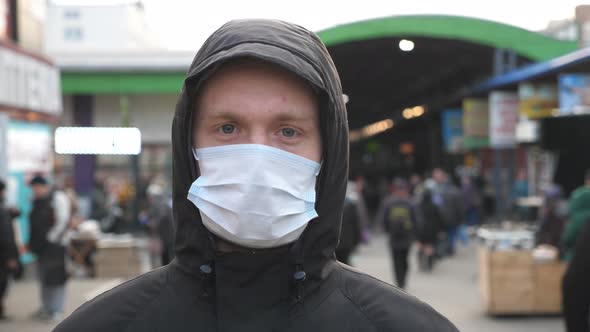 Portrait of Young Man with Medical Face Mask Stands at City Street. Guy Wearing Protective Mask From