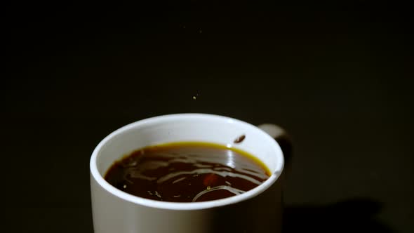 Coffee beans falling into a coffee mug, Ultra Slow Motion