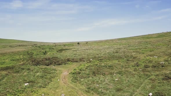 Rising aerial view of Dartmoor National Park in Devon, UK.