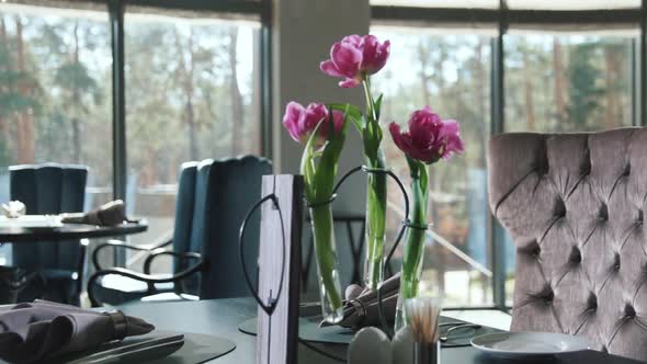 Plate with Napkin and Cutlery for Dinner in Restaurant. Flowers on Dining Table