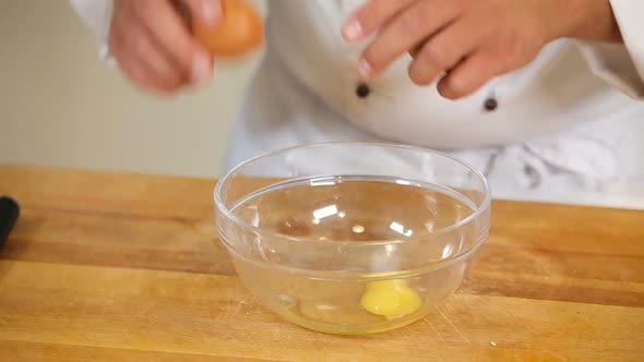 Breaking Eggs Into Glass Bowl