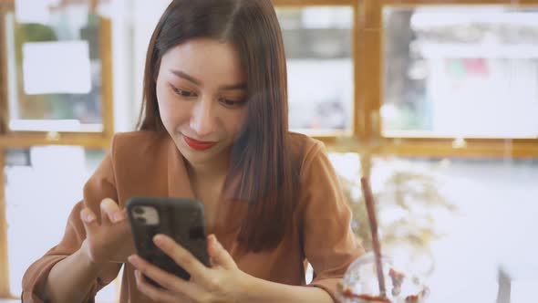 Hands of Young Woman Using Smartphone in Cafe