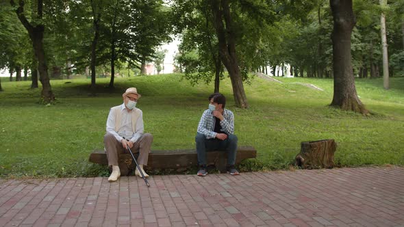 Old Father and Son Sitting in the Park on a Bench