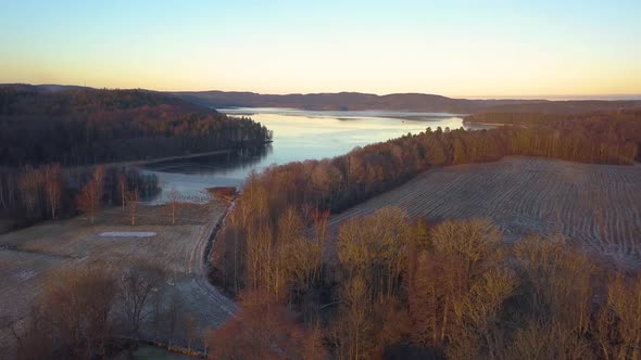 Areal shot of a big swedish lake in the winter. Filmed in sunset with red colors.