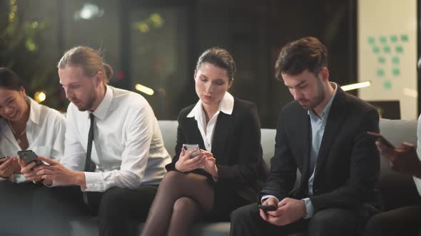 Group of People Sitting in the Waiting Room and Use Smartphones the Office Team Is Waiting for the