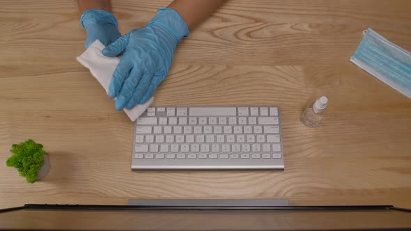 A Business Man in Protective Gloves Disinfects a Computer Mouse with an Antiseptic and Types on a