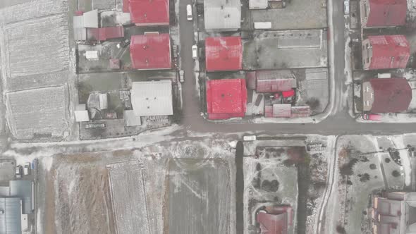 Top down overhead Aerial over houses with red roofs during snow storm