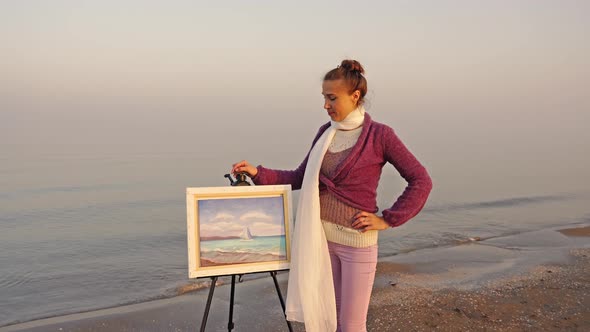 Elegant Woman Stands Near Easel with Seascape Painting