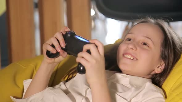 A Happy Child is Playing on a Game Console a Teenage Girl is Holding a Game Joystick