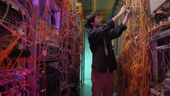 Portrait of Asian IT Administrator Checking Server Wires