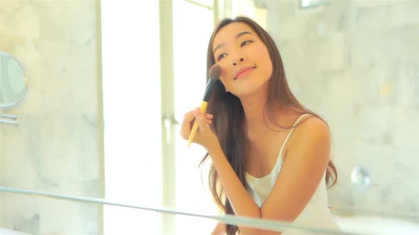 Young asian woman check her face on mirror