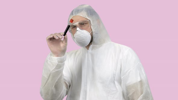 Medical Worker in Protective Clothing Exploring Blood Test Capsule Tube