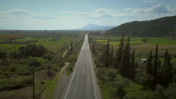 Aerial view of long straight road in the countryside in Greece.