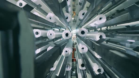 Paper Rolls Moving Along with the Vertical Conveyor at a Paper Plant