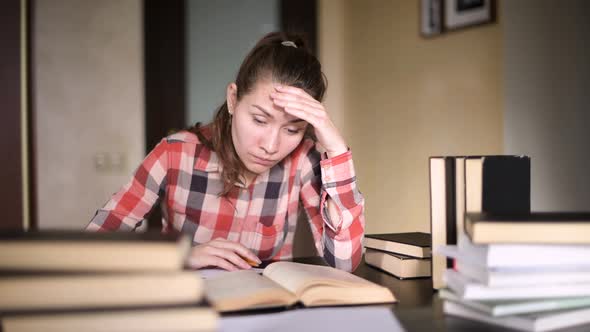 student girl tired of studying, took off glasses and rubbed her face with hand