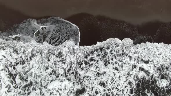 Top-down aerial view of waves at Seixal black sand beach, Madeira, Portugal