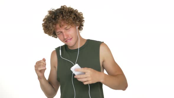 Young Man Enjoying Listening to Favourite Music on Mobile Via Headphones Dancing Smiling Touching