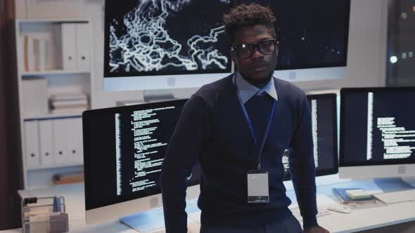 Black Programmer Posing by Monitors