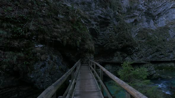 A wooden bridge over a river in a gorge