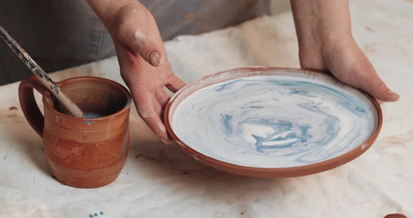 Skilled Potter Glaze Covers the Plate From Red Clay. Close Up. Process. Ceramic Workshop