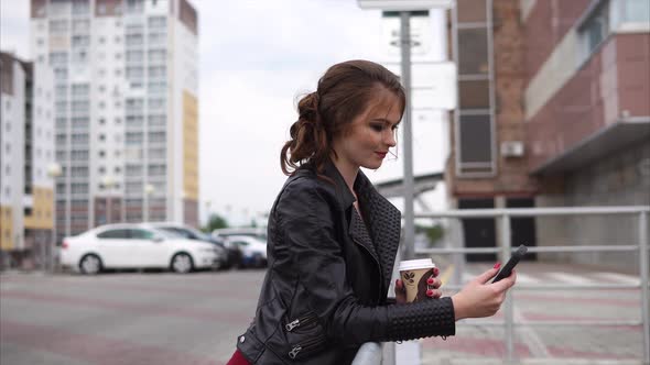 Pretty Brunette with Cell and Coffee in the Street