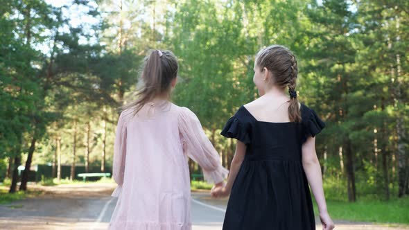 Schoolgirls Walk Together Joining Hands in Park Closeup