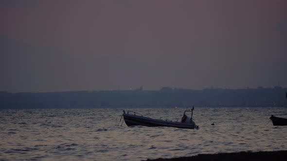 Evening scene of sea with moored boat rocking on waves