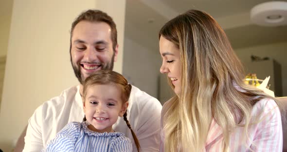 Portrait of Happy Family, Little Girl with Mother and Father at Home