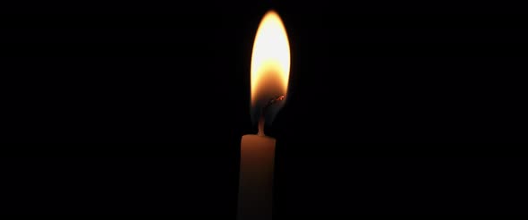 Close up single candle flame with a black background