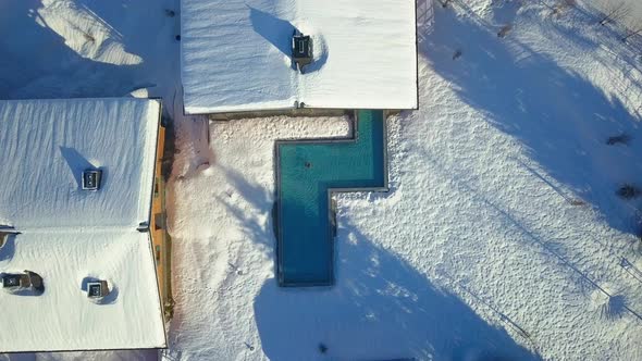 Aerial drone view of a woman swimming in a pool at a luxury spa resort.