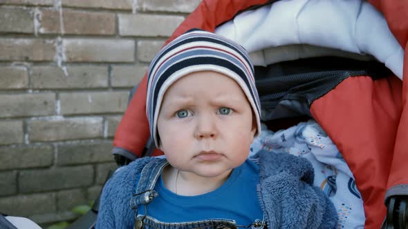 portrait of a baby looking at the camera and stretching his arms towards her. Slow motion