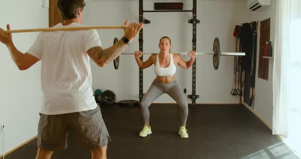 Strong female athlete squatting with barbell