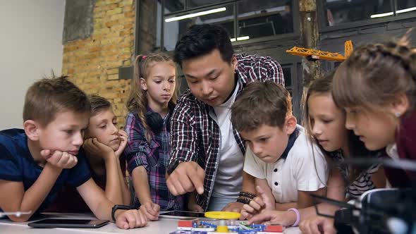 Creative Children with Teacher Launching Electronic Constructor with Fan and Turning Flashlight