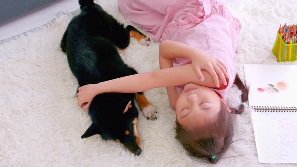 Asian little girl sleeping with her dog on the floor at home.