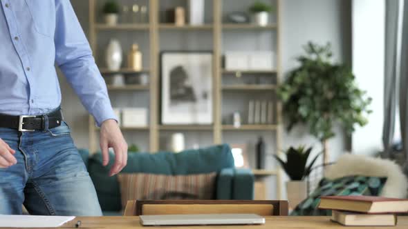 Casual Businessman Coming Sitting and Opening Laptop at Work