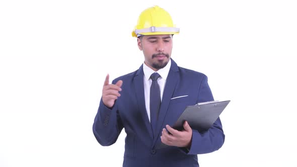 Happy Bearded Persian Businessman As Engineer Talking While Holding Clipboard