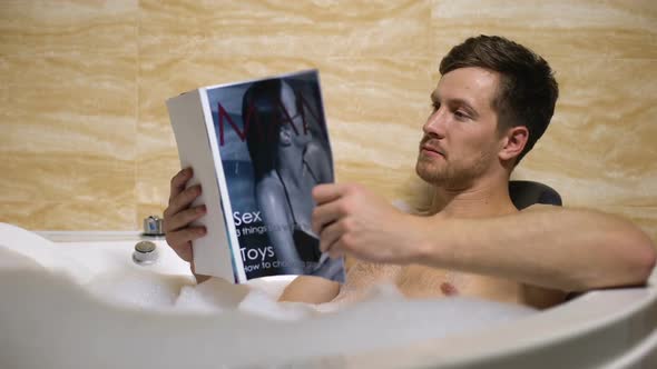 Masculine Guy Taking Warm Relaxing Bath and Reading Mens Magazine, Fresh News