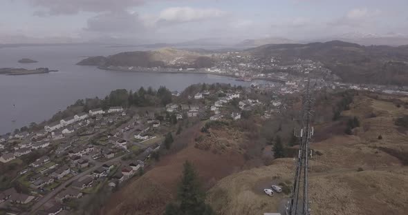 Aerial push in shot of Oban from the radio mast on a cloudy day headed north west