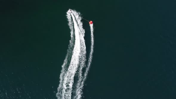 Happy People Swim on Air Mattress Behind a High Speed Water Bike