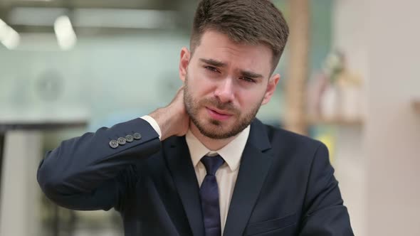 Stressed Young Businessman Having Neck Pain