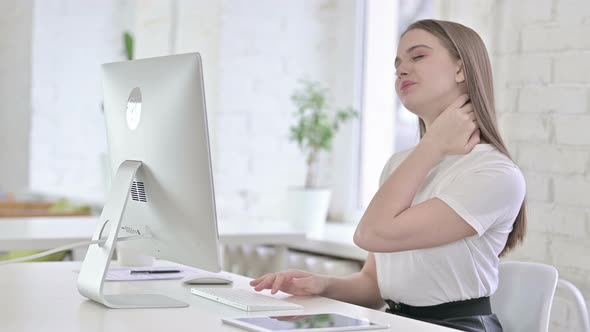 Young Woman Having Neck Pain in Office