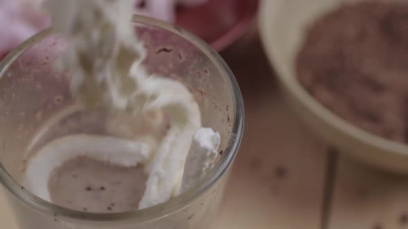 Fresh whipped cream over hot chocolate with marshmallow and chocolate ingredients