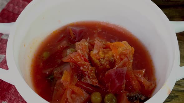 Ukrainian Vegetable Soup or Borscht are Pouring with Ladle in White Bowl