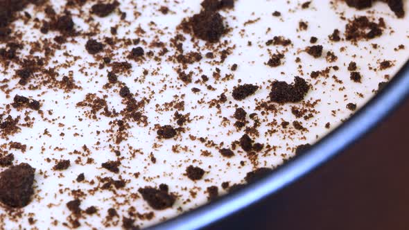 Close up view of homemade chocolate and cream cheese cake into a metal pot, rotating. Macro shot.