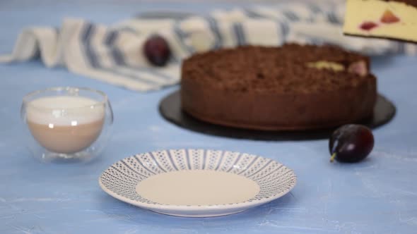 Piece of delicious homemade cheesecake with plums and chocolate crumble.