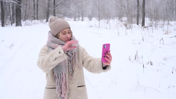 Young Caucasian Woman Talking Deaf Russian Over Video Communication on Smartphone Outdoors in Winter