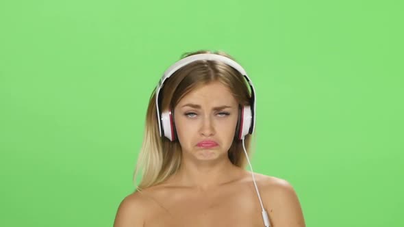 Sad Beautiful Blonde Girl Dancing with Headphones Isolated on a Green Screen